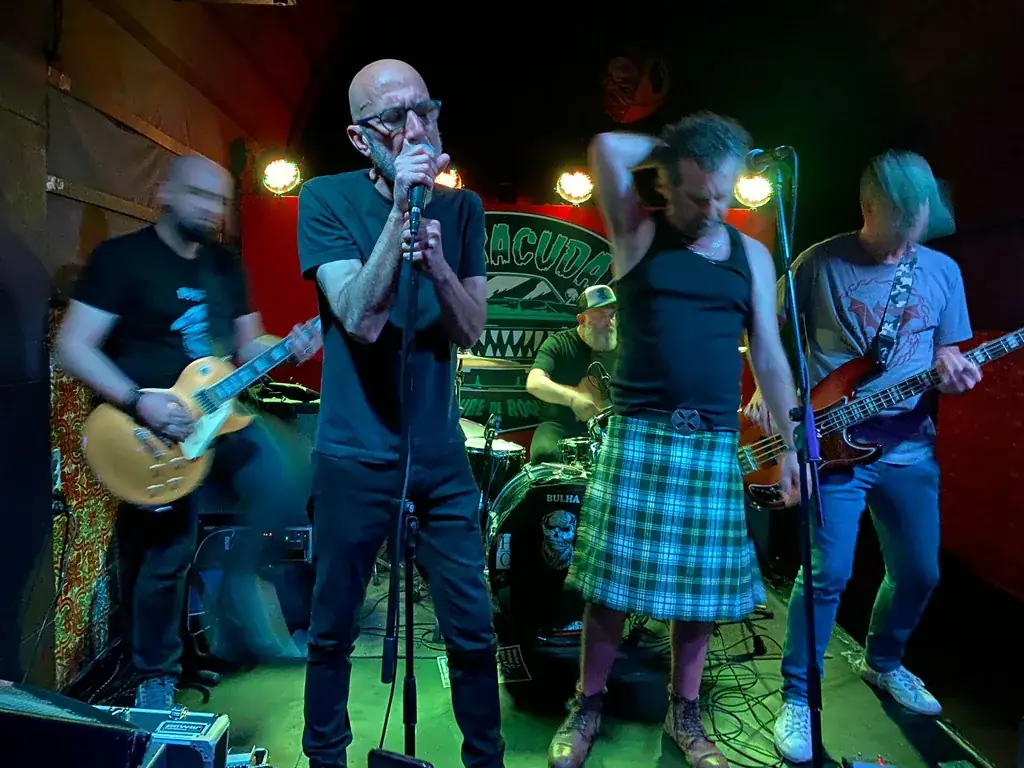 A Bulha em palco, com os dois vocalistas ao centro e iluminação verde
